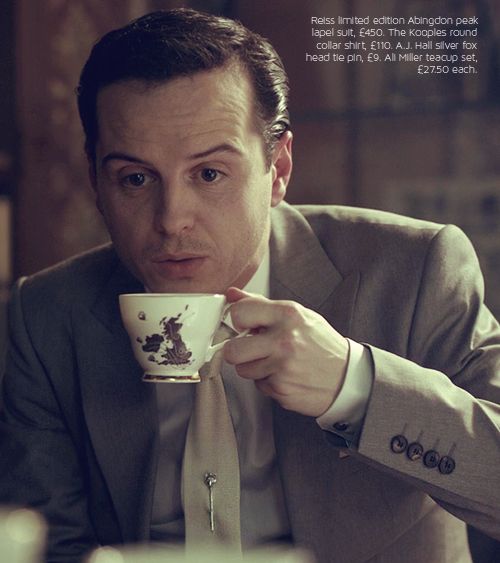 a man in a suit holding a coffee cup