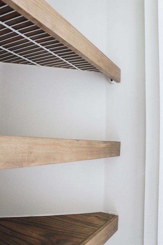 the shelves are made out of wood and have metal grates on them for storage