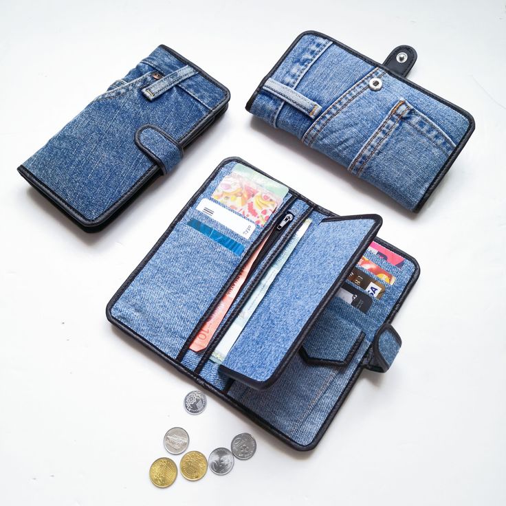 three wallets are open and sitting next to some coins