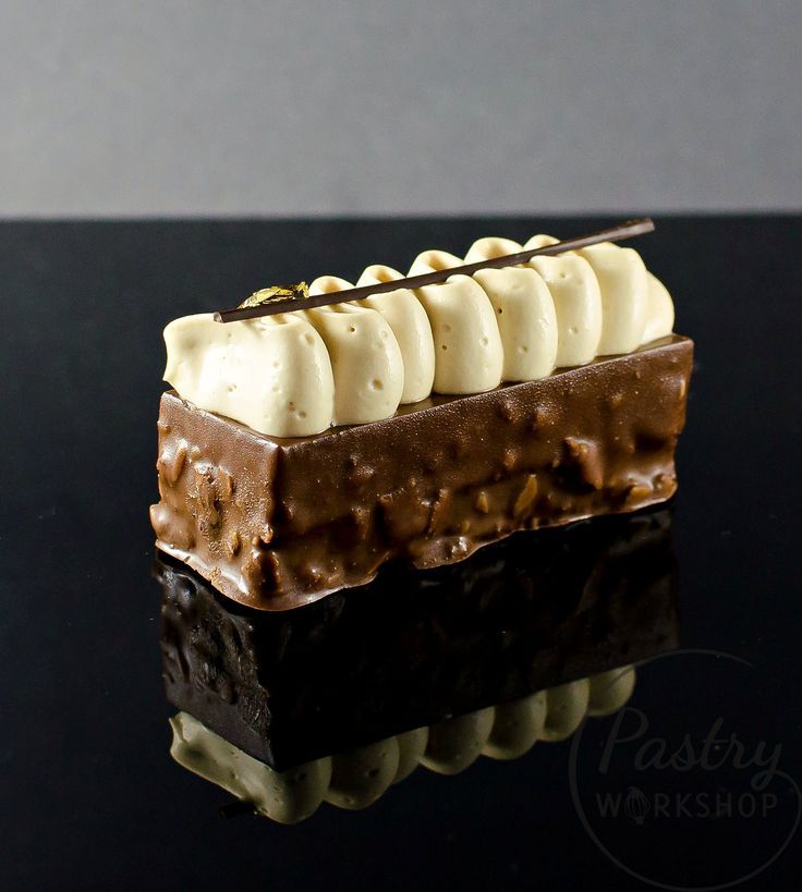 a piece of chocolate cake with banana slices on top, sitting on a black surface