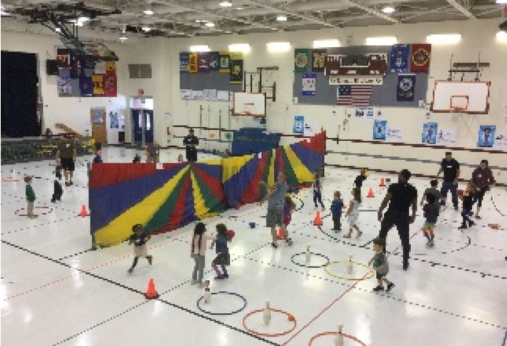 an indoor basketball court with people playing and having fun