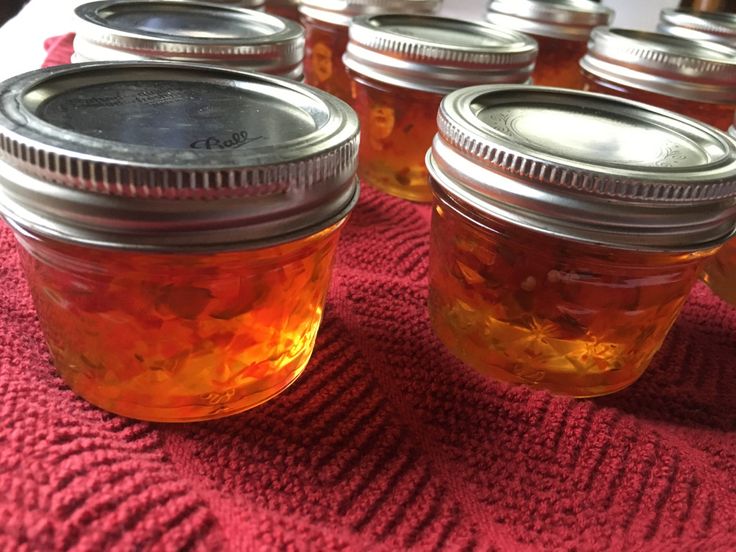 there are many jars with food inside of them on the tableclothed cloth next to each other