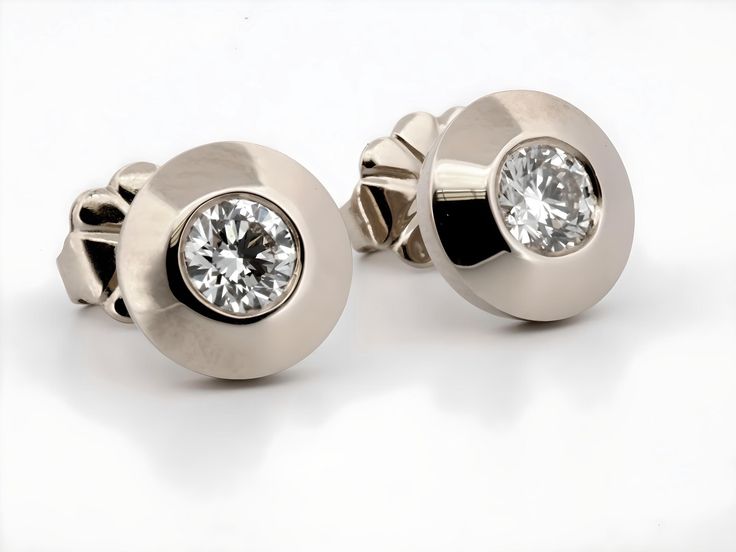 These stunning earrings are crafted from luxurious 14K white gold, exuding a timeless elegance that is both modern and classic. Each earring is set with a brilliant round-cut natural diamond, totaling 0.40 carats across the pair. The diamonds are securely nestled within the gold, creating a captivating contrast between the warm golden hue and the sparkling clarity of the gemstones. These earrings are perfect for adding a touch of sophistication to any outfit, whether for everyday wear or special occasions. The design is both refined and versatile, making these earrings an exquisite addition to any jewelry collection. -14 Karat White Gold -7.45 millimeters Wide overall -Natural Diamonds -G/H Color, SI1 Clarity -Round Brilliant Cut Returns: I gladly accept returns and exchanges Contact me wi Luxury Polished Diamond Earrings For Anniversary, Luxury Diamond Earrings For Anniversary With Polished Finish, Formal Fine Jewelry Diamond Earrings With Polished Finish, Polished Diamond Round Cut Earrings, Modern Single Diamond Round Cut Earrings, Polished Cubic Zirconia Diamond Earrings For Anniversary, Formal Diamond White Platinum Diamond Earrings, Wedding Diamond Earrings With Polished Finish, Formal Platinum Diamond White Diamond Earrings