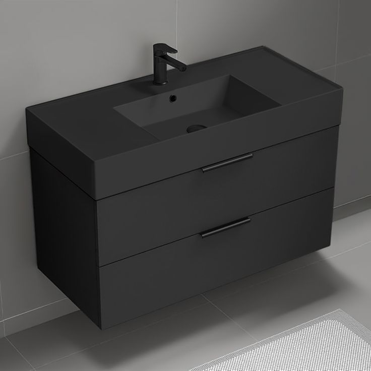 a bathroom sink sitting next to a wall mounted faucet on a tiled floor