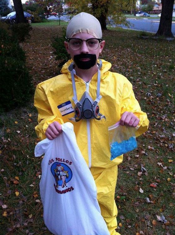 a man in a yellow suit holding two bags and wearing a gas mask on his face