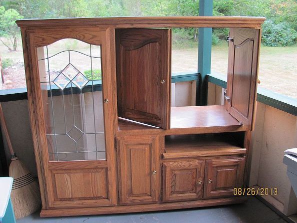 an entertainment center with stained glass doors and drawers