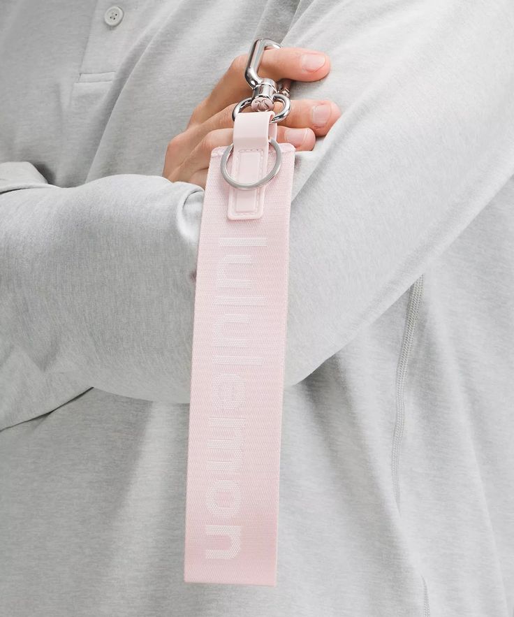 a man wearing a pink tie with the word love on it and a keychain around his neck