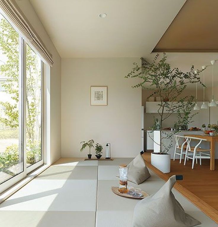 a living room filled with furniture and large windows