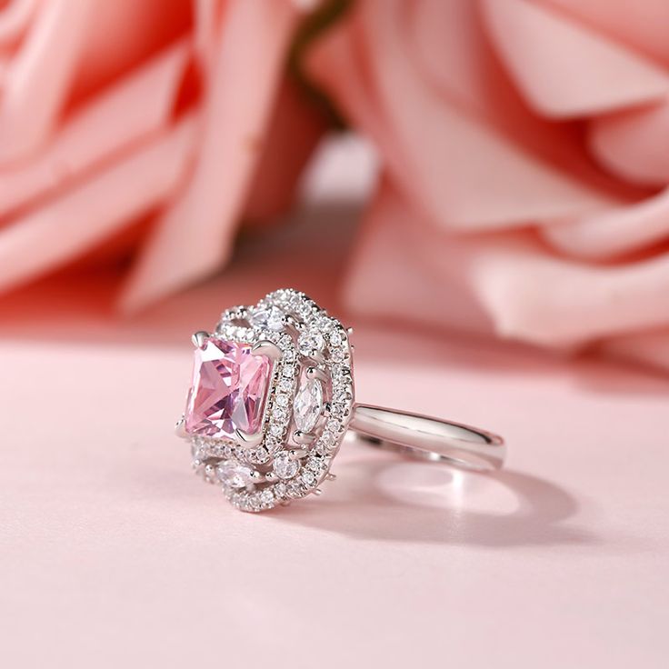 Displaying vivacious feminine flair, this striking fashion ring highlights all that makes her truly exceptional. Crafted in sterling silver, this pretty and unconventional look showcases an radiant cut center stone. Dazzling marquise and round cut stones in a floral frame - touched by glistening round stones - surround the center stone, completing this bold yet winsome style. Buffed to a brilliant luster, this fabulous conversation piece is sure to be worn often.Carat Weight: 2.8 ctStone Size: 7*7 mmStone Type: Jeulia® StoneNumber of Stones: 1 Stone Shape: PrincessStone Color: Fancy PinkCarat Weight: 1.362 ctStone Size: 2*4,0.9,2,1.5 mmStone Type: Jeulia® StoneNumber of Stones: 84 Stone Shape: Marquise, RoundStone Color: Diamond WhiteWeight: 5.67 gWidth: 16 mmHeight: 8.9 mmThickness: 2.7 m Fine Jewelry Radiant Cut Cubic Zirconia Ring, Radiant Cut Cubic Zirconia Ring Fine Jewelry, Elegant Pink Topaz Ring In Sterling Silver, Fine Jewelry Cubic Zirconia Ring Radiant Cut, Fine Jewelry Ring With Halo Setting And Radiant Cut, Dazzling Princess Cut Halo Ring As Gift, Elegant Pink Moissanite Ring, Elegant Princess Cut Topaz Ring With Cubic Zirconia, Elegant Princess Cut Topaz And Cubic Zirconia Ring