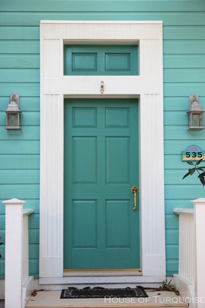 a blue front door with white trim on a house