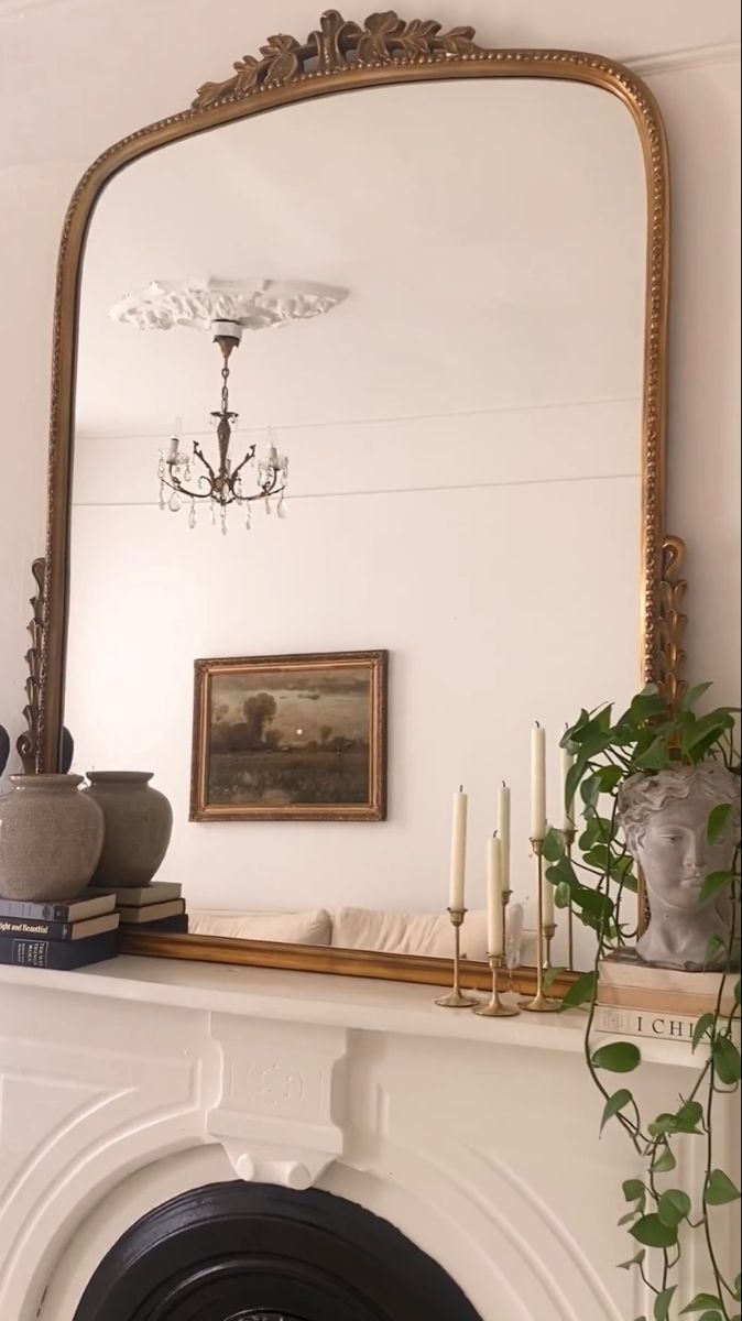 a fireplace with a mirror above it and candles on the mantel in front of it