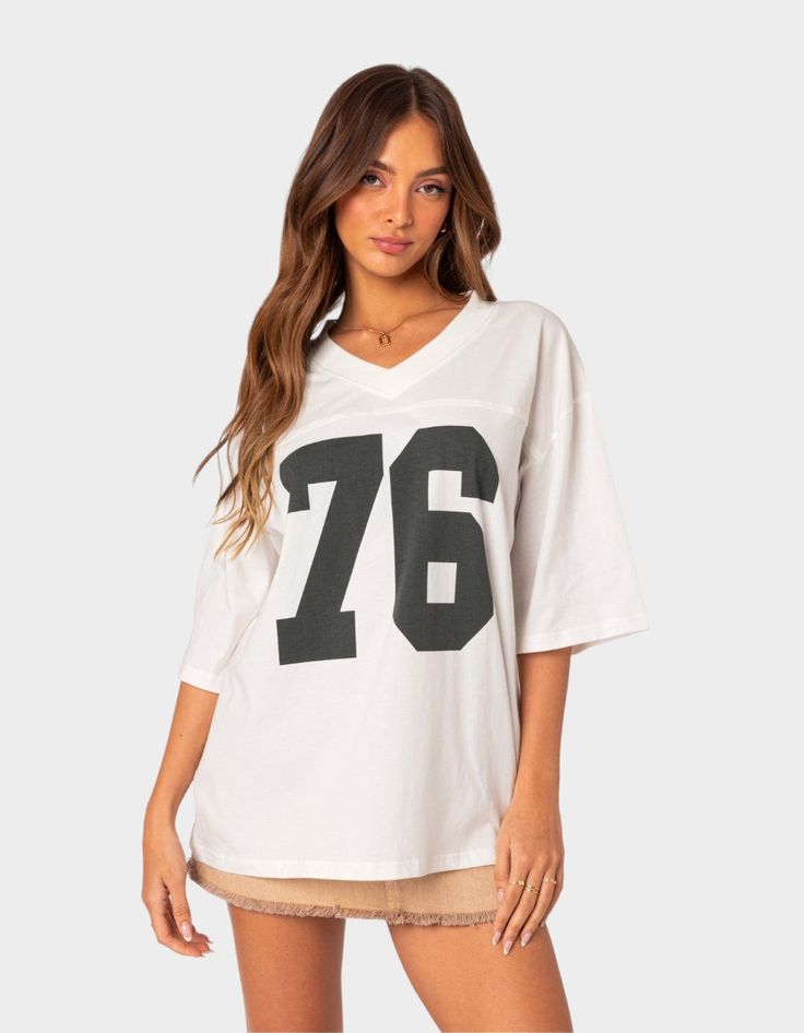 The Perfect Combination Of Comfy And Cool, This Oversized V-Neck Tee Will Have You Looking Sporty And Chic Wherever You Go. T-Shirt. Oversized Fit. Graphic Text. V-Neck. 100% Cotton. Model Wears Size S. Model Height Is 5'9. Item Care: Wash With Similar Color. | Edikted 76 Oversized Tee Oversized Jersey, Flannel Sweatshirt, Retro Jersey, Low Rise Jeans, Sweaters And Jeans, Oversized T Shirt, Top Fabric, Women Trends, Jersey Top