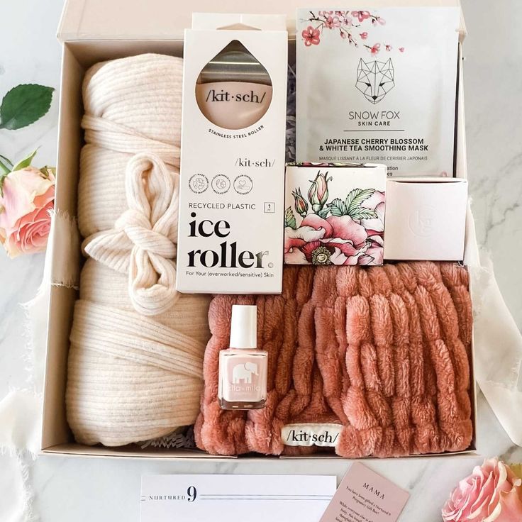 the ice roller box is packed with pink flowers and soaps, an empty notepad, and two rolls of toilet paper