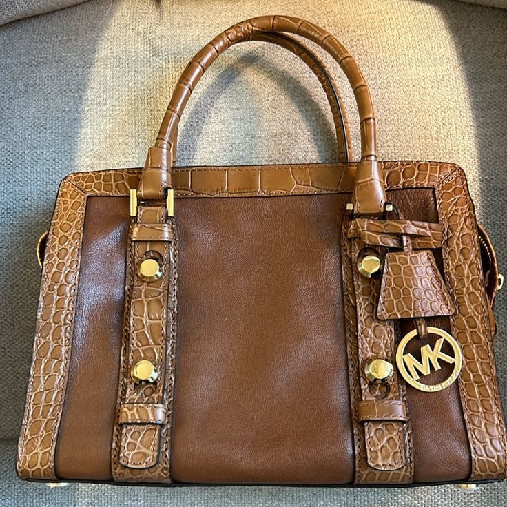 Michael Kors Collins Tan Leather Bag, Gold Hardware, Mint Condition New Without Tags Or Box. No Flaws Found. Still Has The Protective Plastic On Two Of The Feet On The Bottom. Comes With Strap And Dust Bag. Strap Is 37 Inches End To End But Can Be 2 Inches Longer Or 2 To 4 Inches Shorter. 11.25w X 8.5h X 5d Tan Leather Bag, Bags Michael Kors, Michael Kors Bag, Tan Leather, Gold Hardware, Mint Condition, Leather Bag, Satchel, Dust Bag