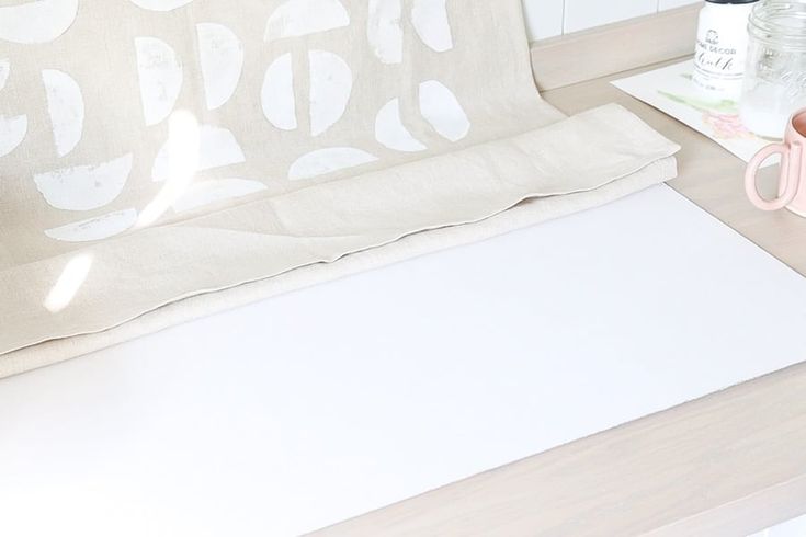 a table with a white sheet and some scissors on it next to a bottle of water