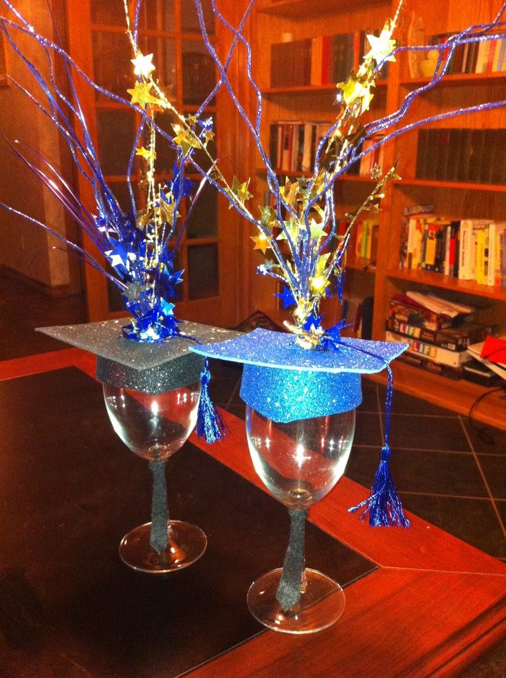 two wine glasses are decorated with blue and gold decorations, while one has a graduation cap on it