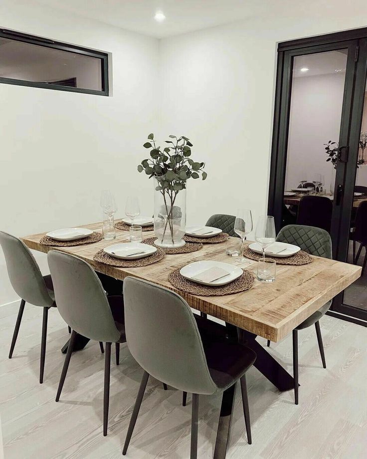 a dining room table is set with place settings for six people and the walls are painted white