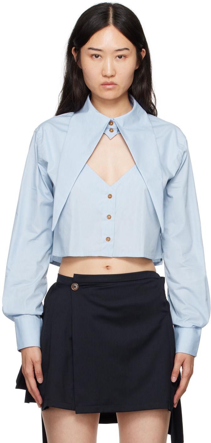 Regenerative cotton poplin shirt. · Extended pointed collar · Button closure · Cutout and logo embroidered at chest · Cropped tennis-tail hem · Two-button surgeon's cuffs Supplier color: Blue Pointed Collar Shirt, Heart Cutout Shirt, Fashion Logo Design Ideas, Cropped Dress Shirt, Cute Button Up Shirts, Vivienne Westwood Top, Vivienne Westwood Shirt, Vivienne Westwood Jeans, Tokyo Outfits