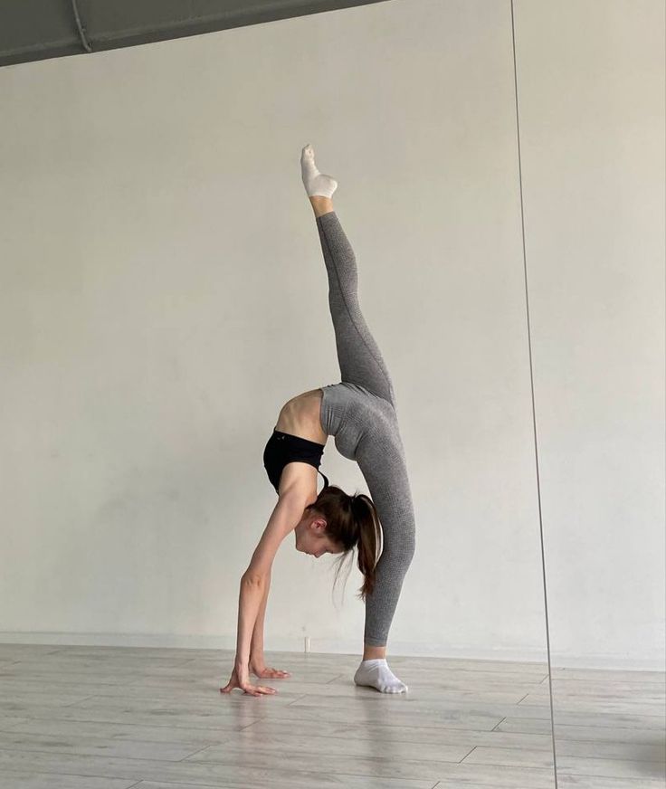 a woman is doing a handstand on the floor