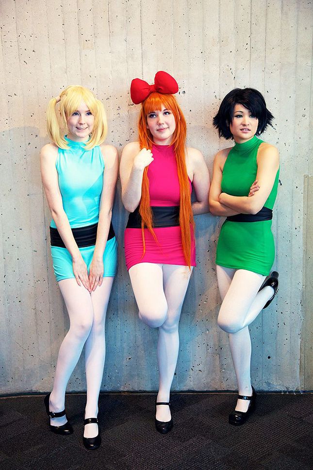 three women dressed in costumes posing for the camera with their hands on their hipss