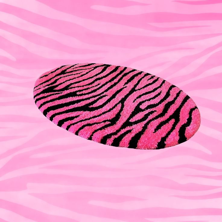 a pink and black zebra print oval shaped object floating in the air over a pink background