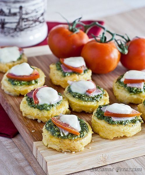 small appetizers with cheese and tomatoes on a cutting board