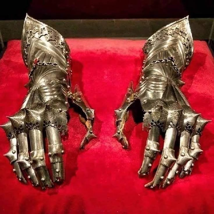 two metal gloves on display in a case