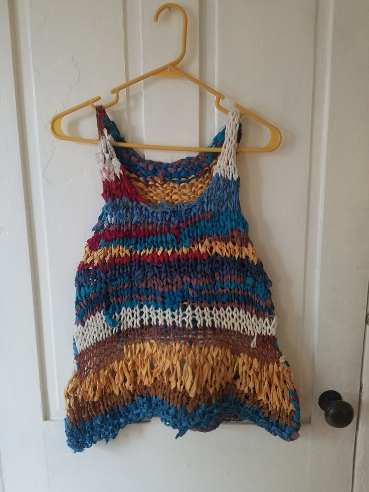 "Scrappy Vest This boho scrap vest/tank is light, airy, and great for warm weather. Layer over a cami, tank, or tee, or even a long-sleeved top.  Size S/M Measurements taken while garment laying flat.  Pit-to-pit: 17\" Bottom hem width: 22\" Length top of strap to hem: 21\" For reference, model is 5'2\", 140 lbs and typically wears size S to M.  Sustainability and environmental responsibility are important to me. For this reason, I primarily use use/incorporate leftovers from my existing yarn st Bohemian Crochet Top For Summer Layering, Bohemian Cami Top For Spring, Bohemian Summer Vest For Layering, Hippie Multicolor Tank Top For Festival, Cotton Cami Vest For The Beach, Cotton Cami Vest For Beach, Multicolor Vest Tank Top For Festival, Hippie Style Tank Top For Spring Beach, Hippie Style Tank Top For Beach In Spring