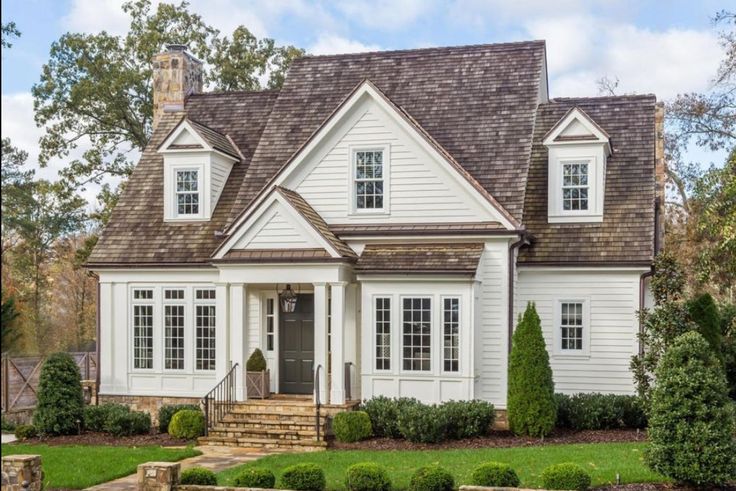 a house with white siding and brown shingles