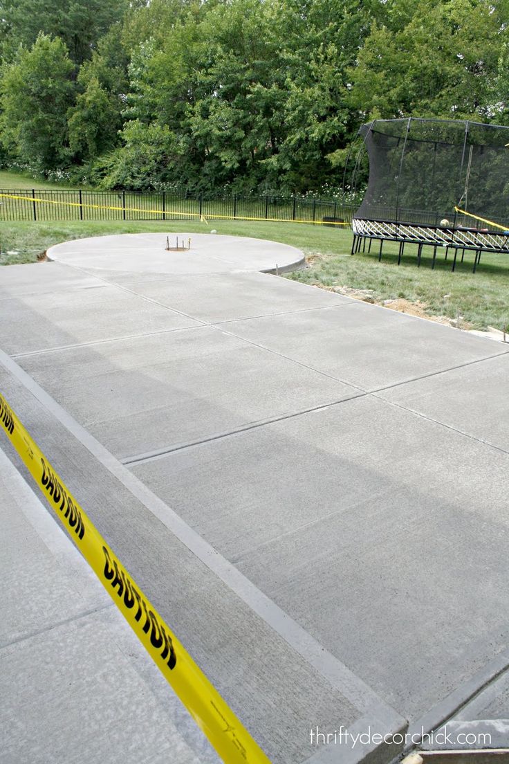 a skateboard park with yellow caution tape on the ground and trees in the background