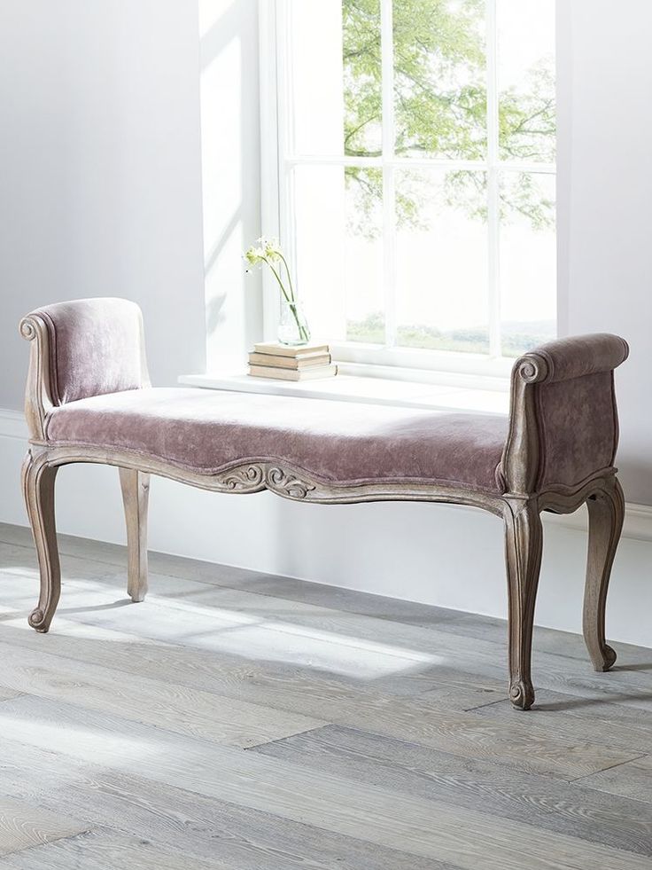 a white bench sitting in front of a window