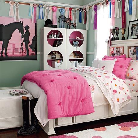 a bedroom decorated in pink and white with horse pictures on the wall above the bed