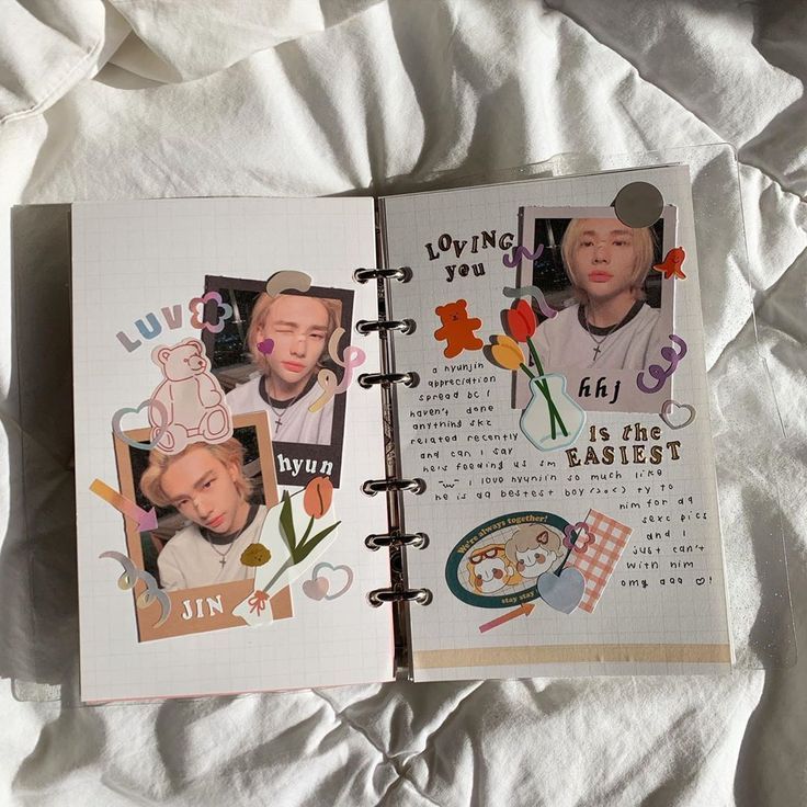 an open notebook with pictures of people and flowers on the pages, sitting on a bed