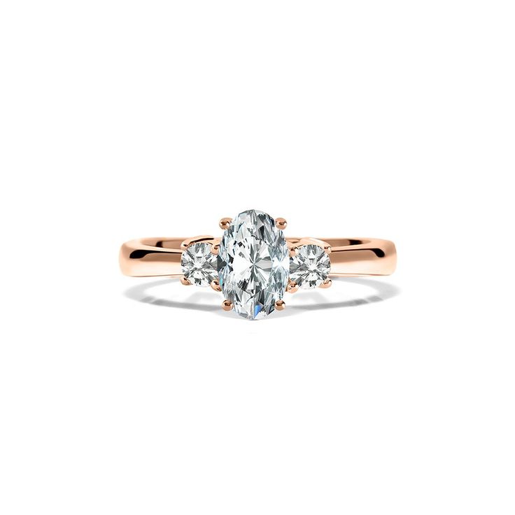 an oval cut diamond ring with three smaller stones on the band, set in 18k rose gold