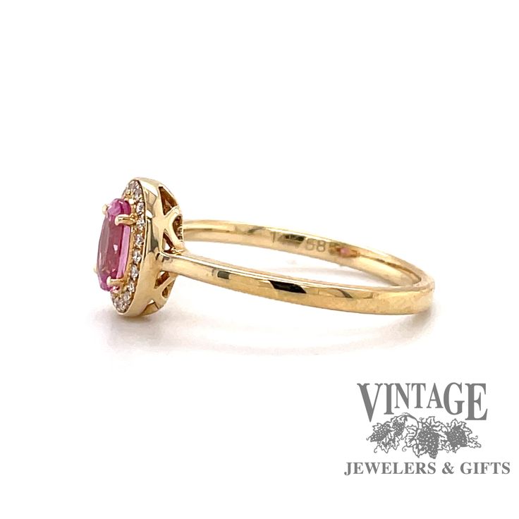 14 karat yellow gold oval pink sapphire and diamond halo ring, angled side view Classic Pink Ruby Ring With Halo Setting, Classic Pink Cluster Ring With Halo Setting, Classic Pink Sapphire Ring With Halo Setting, Pink Ruby Ring With Halo Design, Pink Birthstone Ring With Halo Setting, Oval Ruby Birthstone Ring With Halo Setting, Pink 14k Gold Halo Ring, Oval Pink Sapphire Jewelry With Halo Setting, Pink Oval Sapphire Ring With Halo Setting