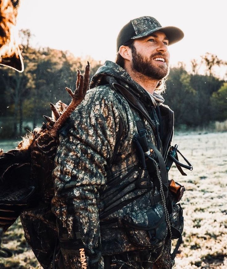 a man with a beard and hunting gear