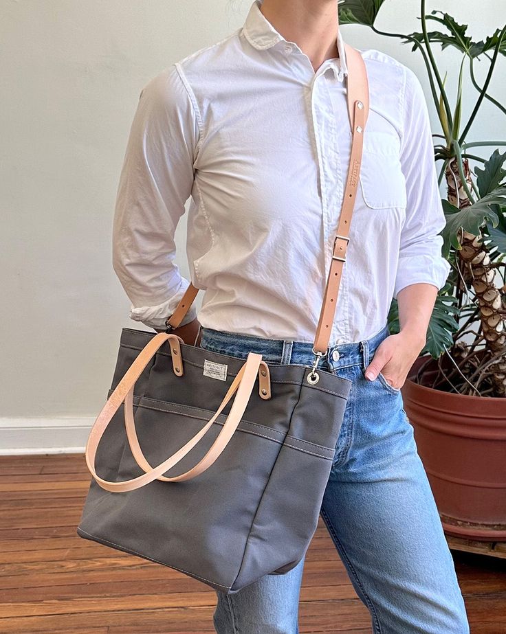 This versatile, fun tote is our best selling go-to for daily carry. Small batch handmade in our Omaha, NE studio using sturdy water repellent duck canvas and American full grain leather. Split Leg Apron, Tote Insert, Crochet Travel, Daily Carry, Canvas Leather Tote, Grill Apron, Lunch Tote Bag, Tote Organization, Knitting Bag