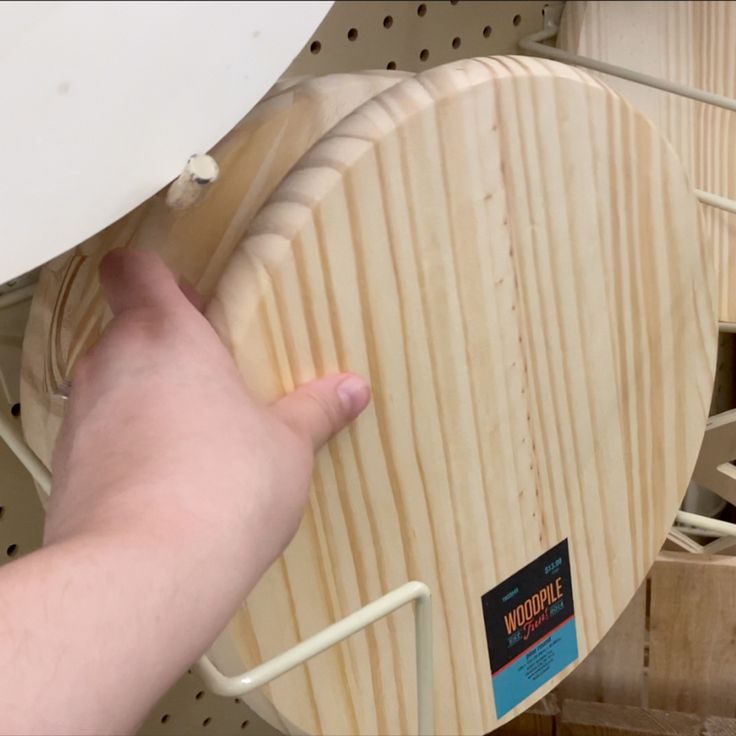 a wooden object being held up by a person's hand in front of it