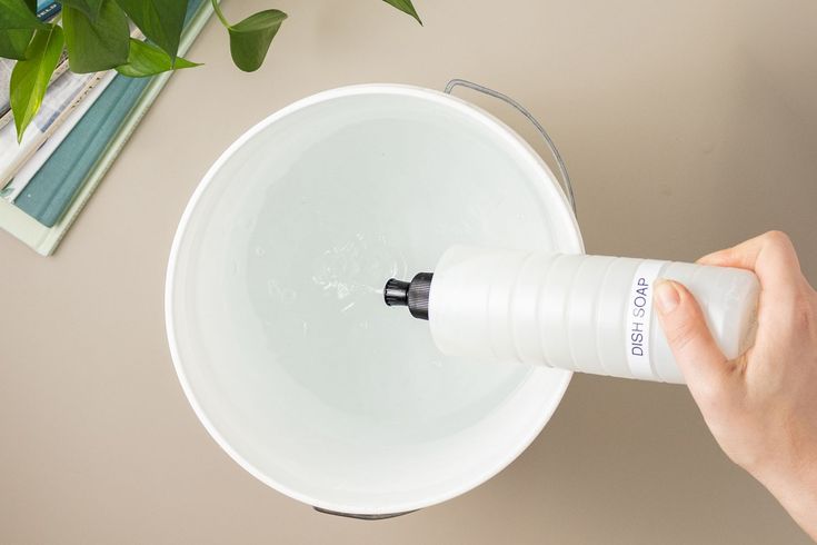 a person is holding an object in their hand and pressing it on the side of a white bowl