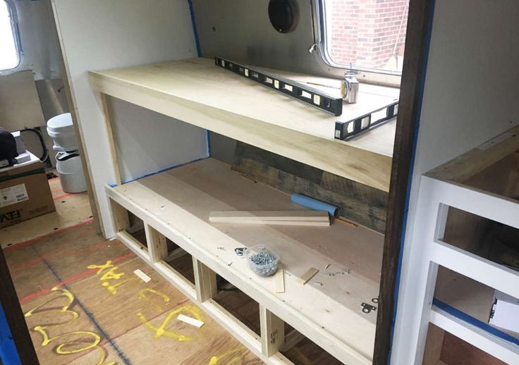 the inside of a trailer with shelves and tools on it's sides, in front of a window