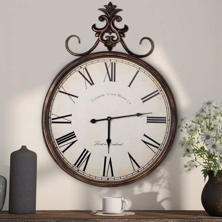 a clock hanging on the wall next to a vase with white flowers and a coffee cup