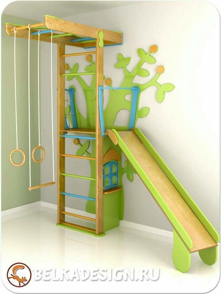 a children's play area with a slide, swing set and tree house on the wall