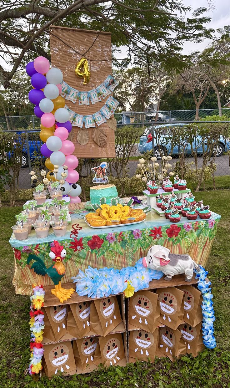 an outdoor dessert table with balloons and decorations