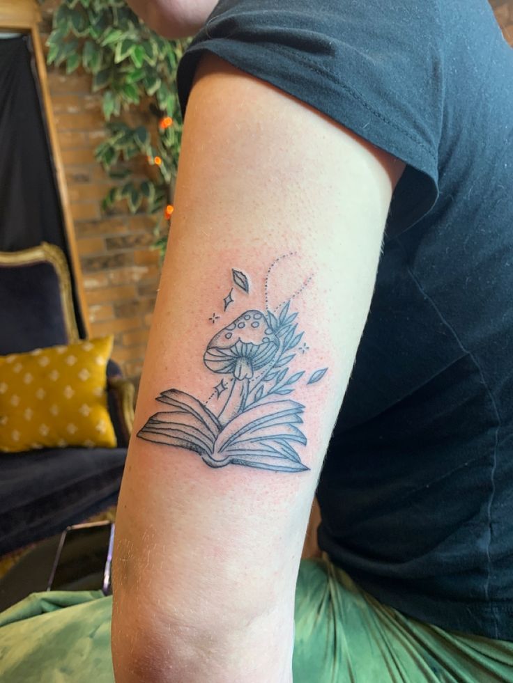 a woman with a book tattoo on her arm