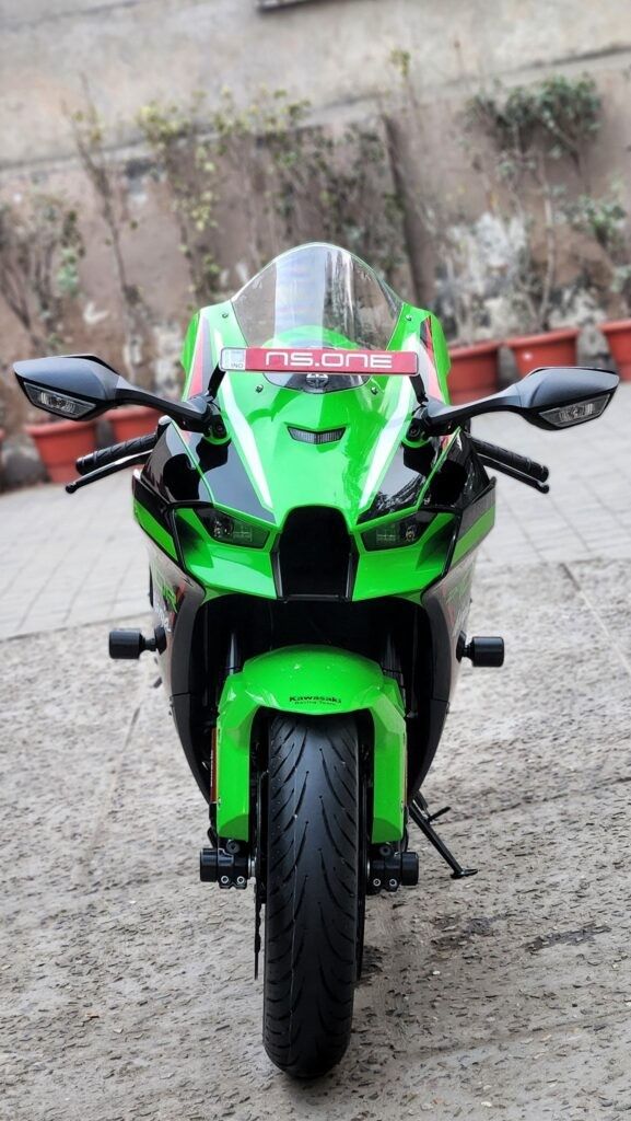 a green and black motorcycle parked in front of a building