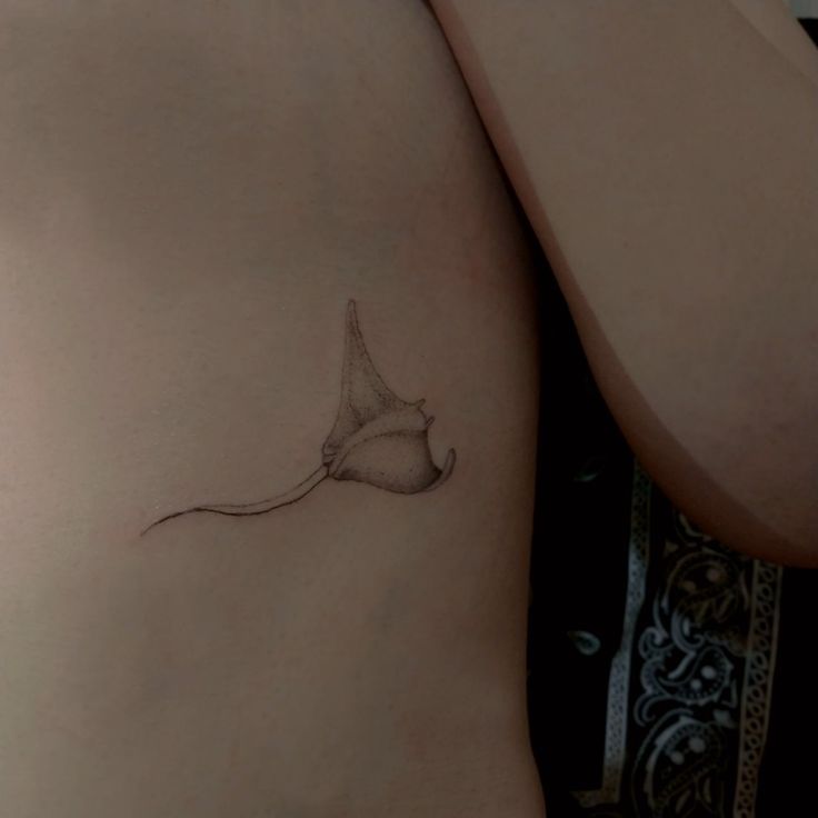 a small tattoo on the back of a woman's stomach