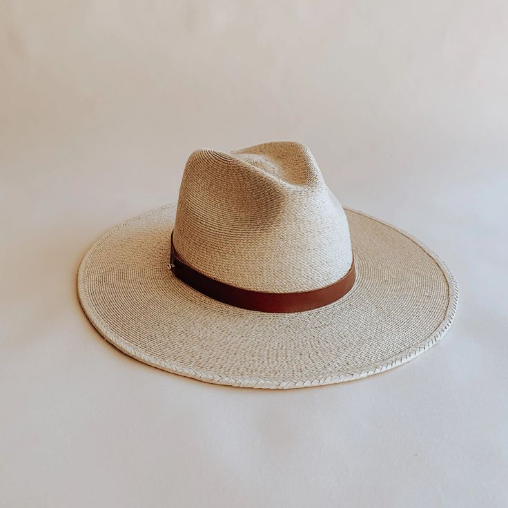 The Soleil straw fedora was thoughtfully designed to be an approachable, ready to wear style that effortlessly tops off any warm weather outfit. Featuring a flat, stiff brim size that measures 3 1/2", and a classic pinch crown fedora shape, the Soleil shines for everyday wear, offering UPF 50+ sun protection. Sustainably harvested tripilla palm straw is lightly toasted, then intricately handwoven by artisans in Puebla, Mexico to create each Soleil style, part of our premium straw hat collection. Adding to the versatility of our headwear, the Soleil's removable and interchangeable, genuine leather hatband with its gold hardware finish has become a Leah hat signature. Available with an adjustable inner, cotton sweatband for a more comfortable fit. Each hat comes with a genuine brown leather Natural Boater Hat With Flat Brim For Everyday, Everyday Natural Boater Hat With Flat Brim, Toquilla Straw Hat With Flat Crown For Vacation, Flat Crown Toquilla Straw Hat For Vacation, Classic Panama Hat With Flat Brim For Everyday, Classic Flat Brim Panama Hat For Everyday, Vacation Hat With Flat Crown In Toquilla Straw, Summer Fedora With Adjustable Flat Crown, Summer Fedora With Short Brim For Everyday