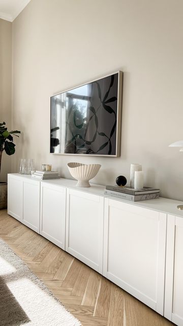 a living room filled with furniture and a large painting on the wall above it's entertainment center