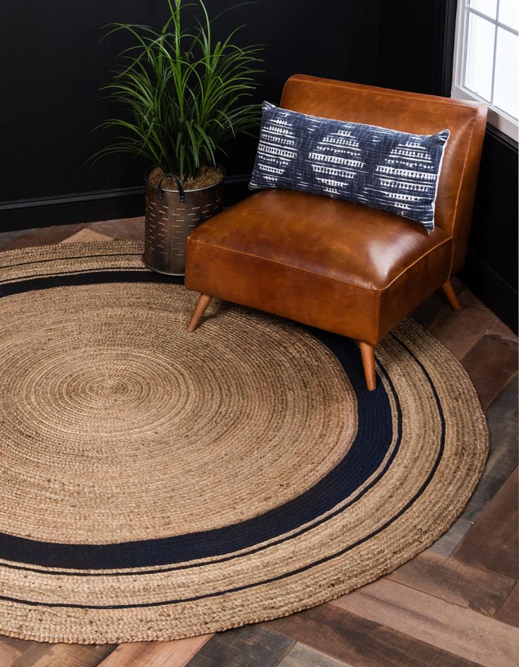 a brown chair sitting on top of a wooden floor next to a potted plant