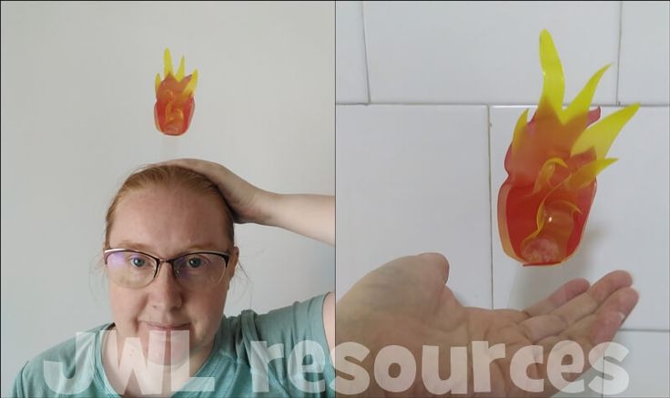 a woman with glasses holding her hands up to the camera and an image of flames coming out of it